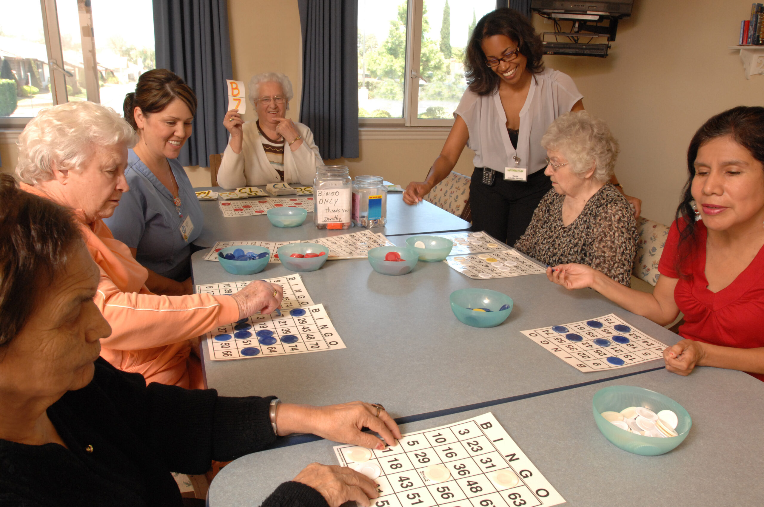 resident senior women sitting at activity table indoors playing bingo