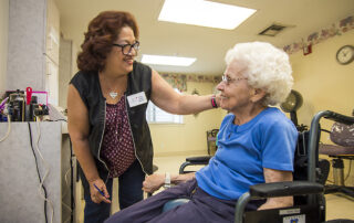 professional hair stylist cutting a senior women's hair in the resident salon