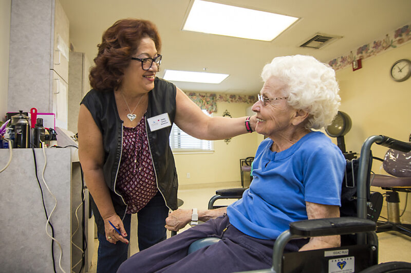 professional hair stylist cutting a senior women's hair in the resident salon