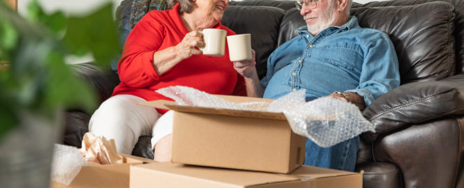 A couple drinking coffee and packing boxes