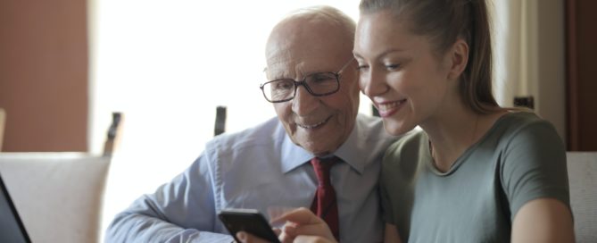 Older man and younger woman looking at phone