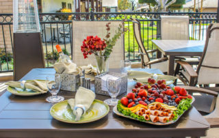 plate of fresh berries and deli meat sitting on a decorated outside patio table