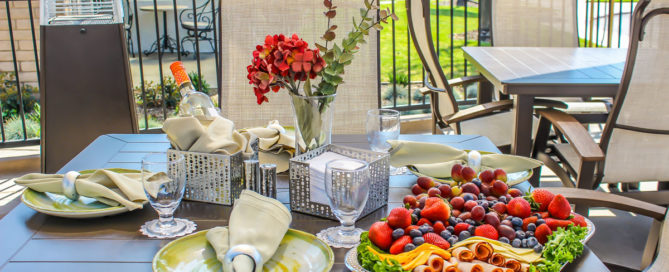 plate of fresh berries and deli meat sitting on a decorated outside patio table