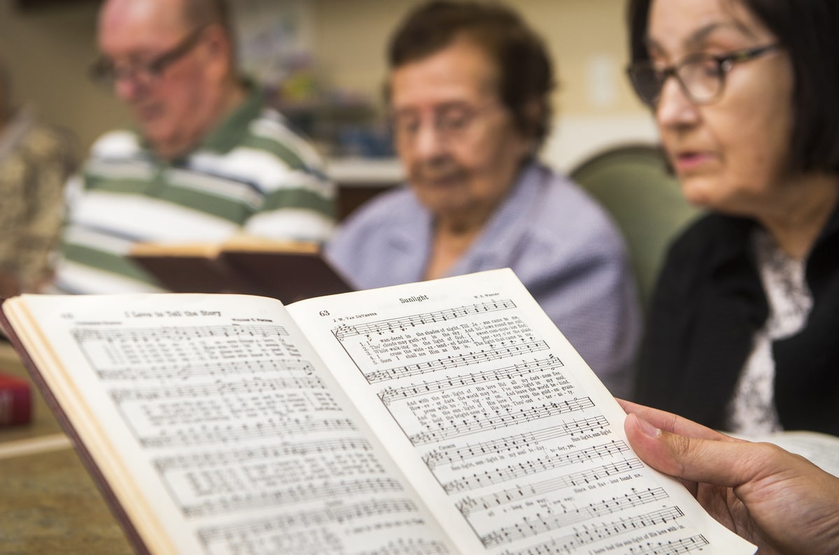 Photo of residents singing and holding hymn books