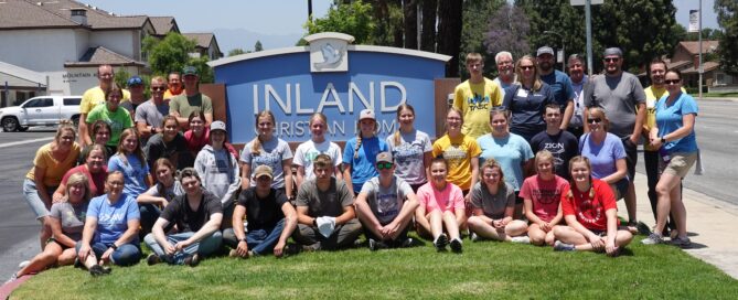 TASC team group photo in front of the large Inland Christian Home sign