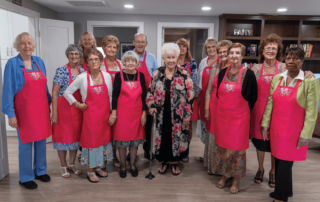 group photo of senior women in pink aprons