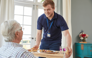 Nurse delivering food to senior