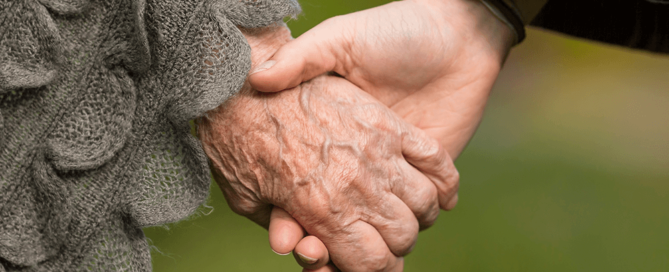 elderly mother and adult child holding hands