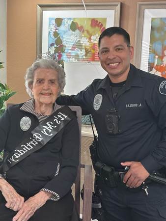 Resident Betty Nehrig posing with smiling police officer