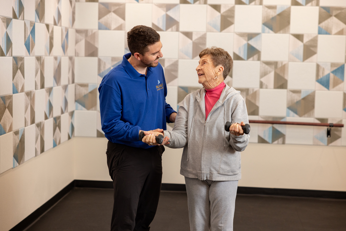 male physical trainer with senior exercising