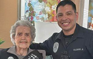 Resident Betty Nehrig posing with smiling police officer