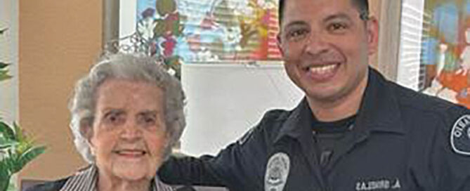 Resident Betty Nehrig posing with smiling police officer