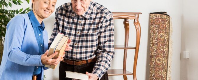 woman helping senior man pack books into a moving box