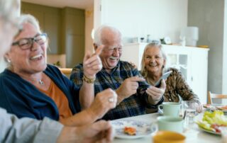 seniors eating a meal and laughing as friends